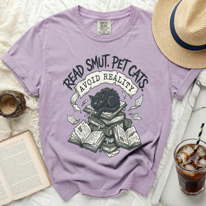 Purple t-shirt with graphic of black cat on books, text "Read Smut. Pet Cats. Avoid Reality."