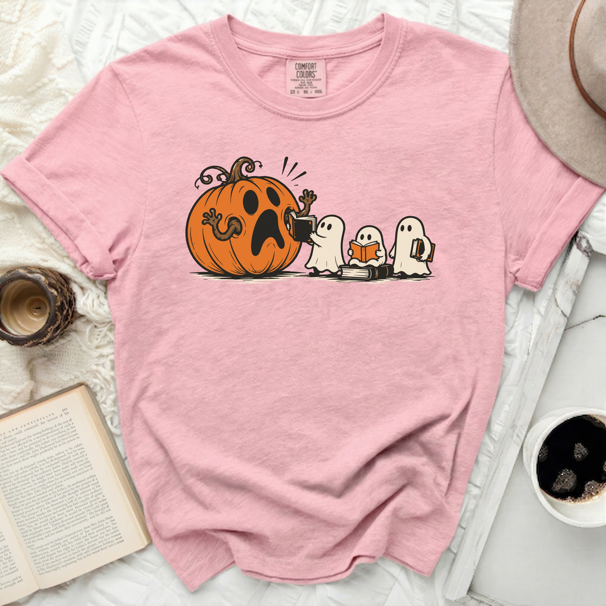 Pink t-shirt with cartoon pumpkin and ghosts reading books graphic