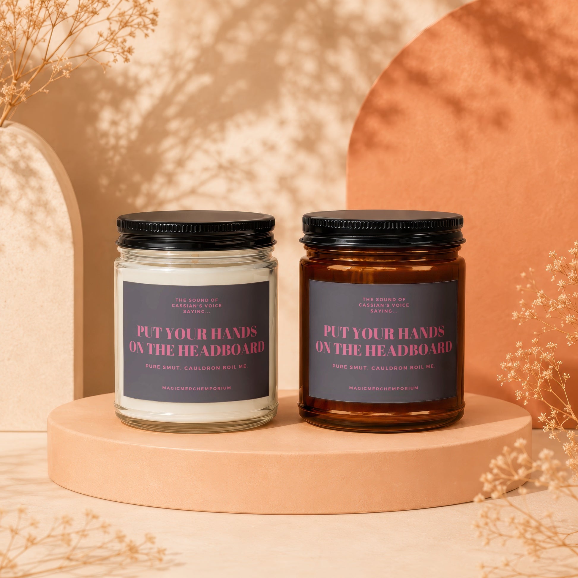 Two candles with labels that read "Put Your Hands On The Headboard".
