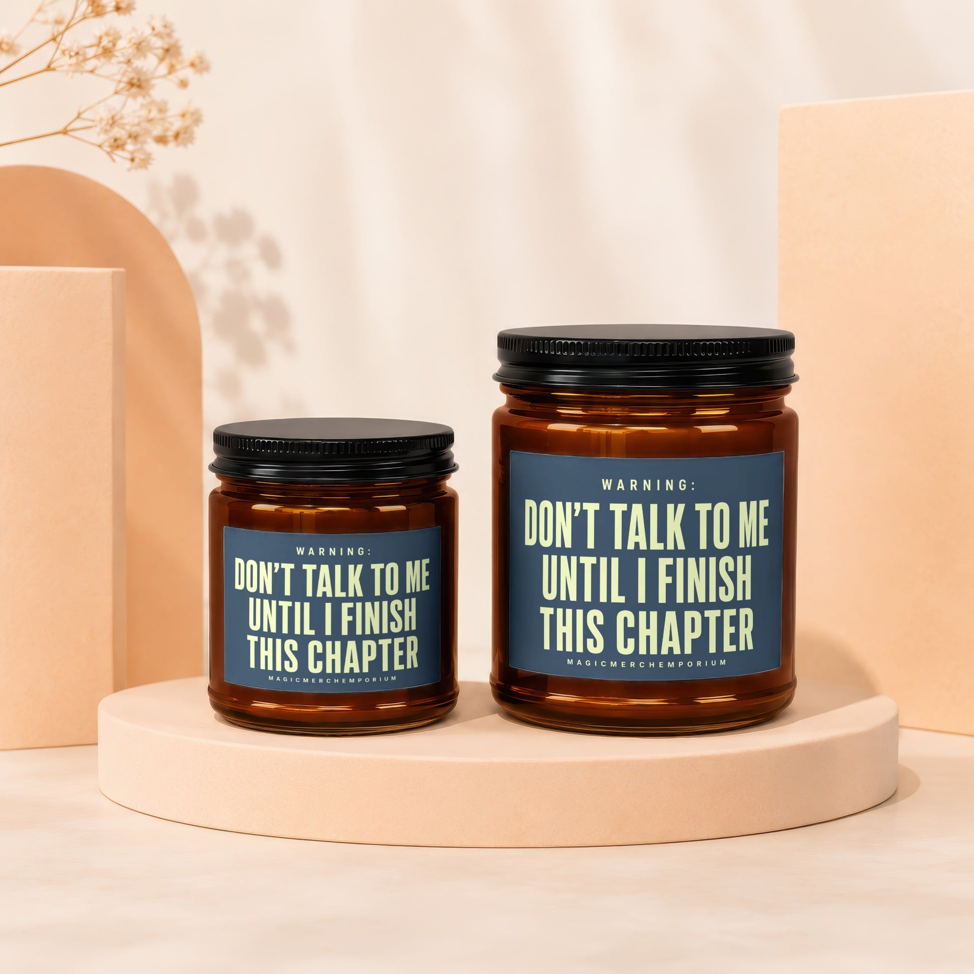 Two brown glass candles with blue labels stating "Don't talk to me until I finish this chapter".