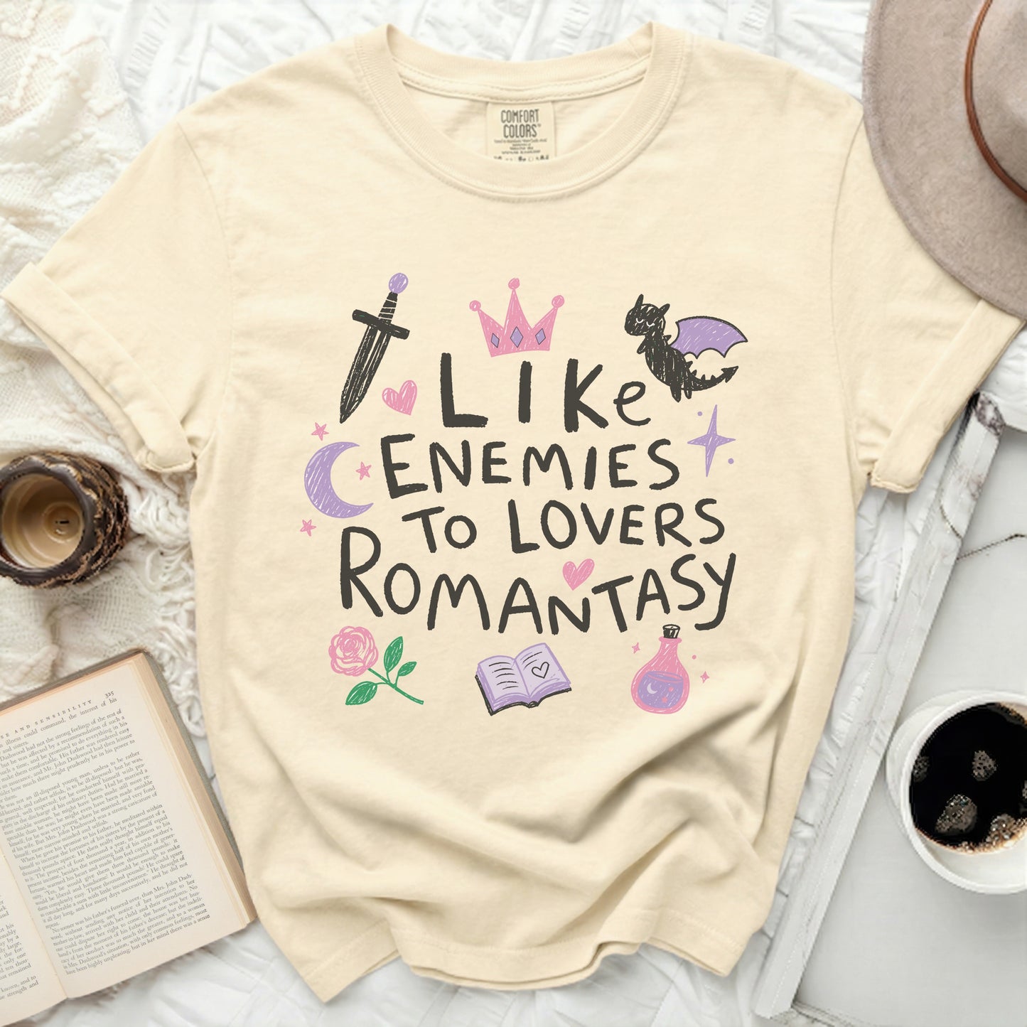 Cream t-shirt with "Like Enemies to Lovers Romantasy" text and fantasy icons.