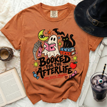 Orange t-shirt with Halloween ghost, cat, and book graphic: "Booked for the Afterlife".