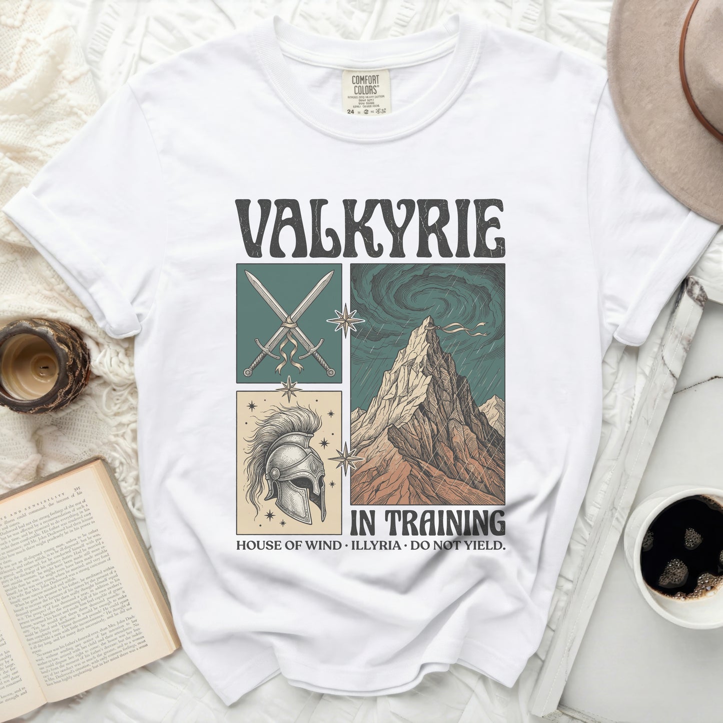 White t-shirt with "VALKYRIE IN TRAINING" graphic featuring swords, helmet, and mountains.