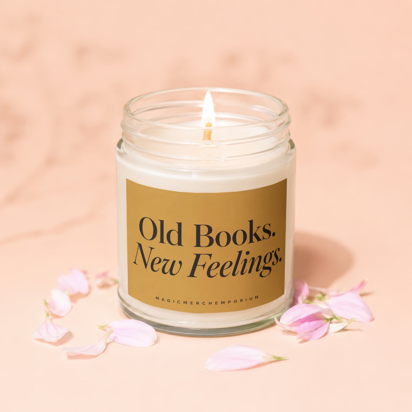 Lit candle in glass jar with gold label reading "Old Books. New Feelings."