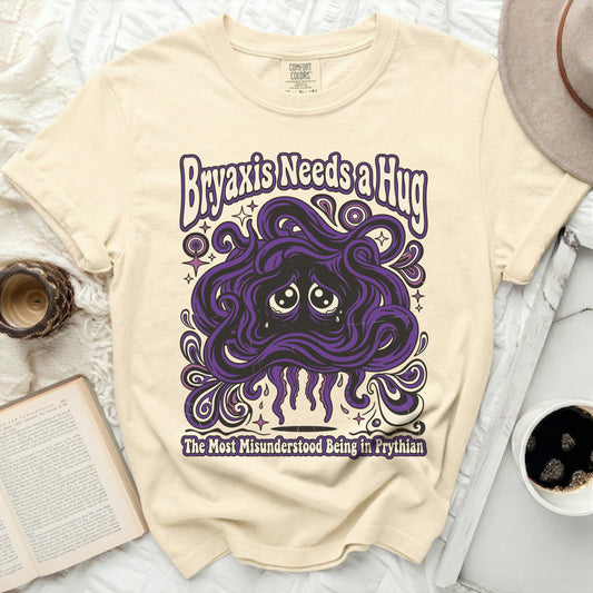 Cream t-shirt with graphic "Bryaxis Needs a Hug" and a sad purple creature.