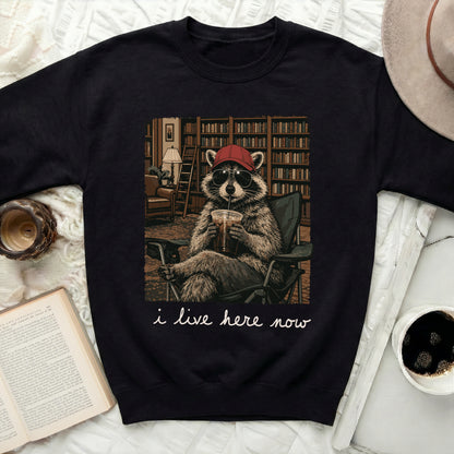 Black sweatshirt with raccoon wearing sunglasses and drinking from cup.