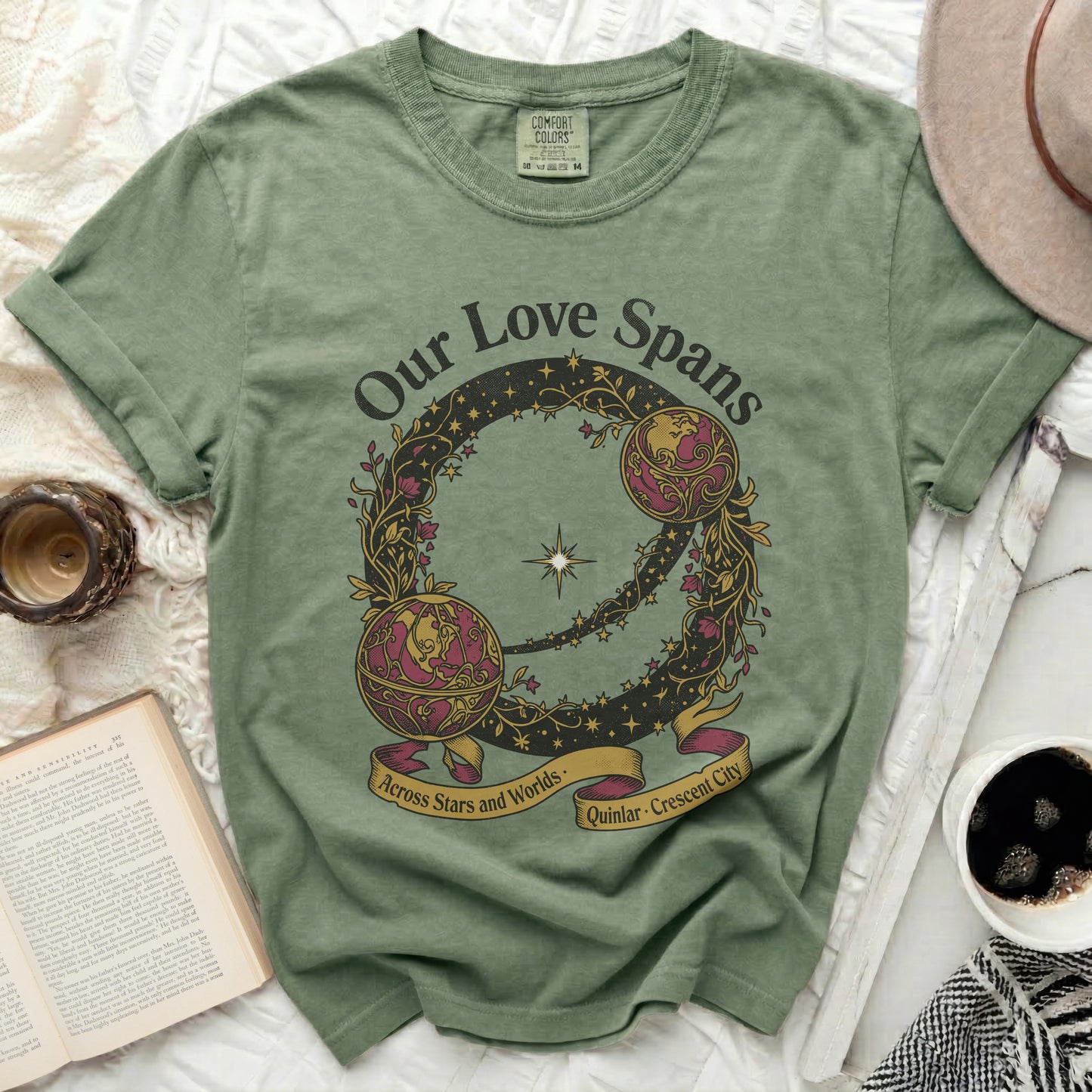 Green t-shirt with circular "Our Love Spans" graphic across stars and worlds.
