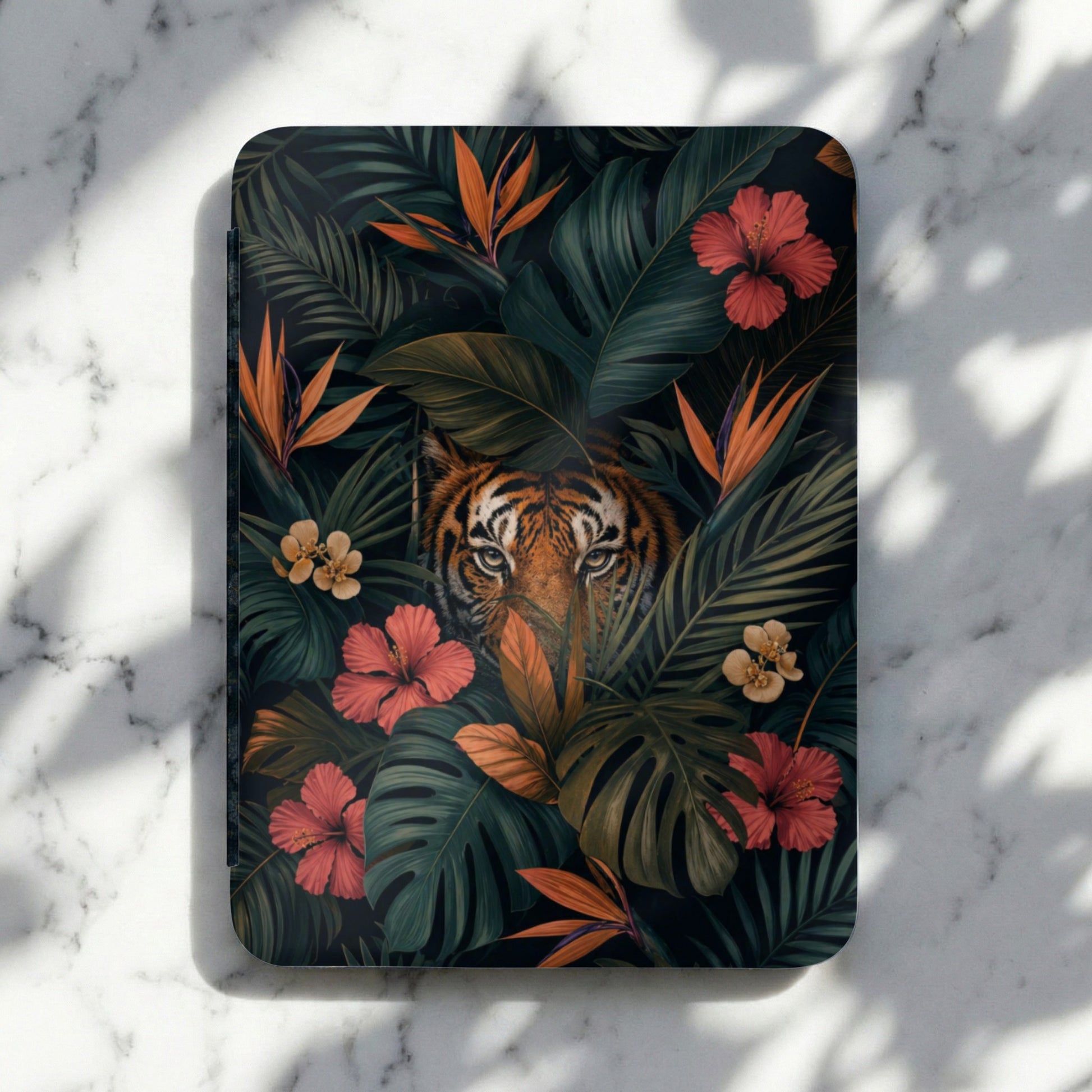 Journal with tiger face and tropical flowers and leaves in a dark jungle setting.