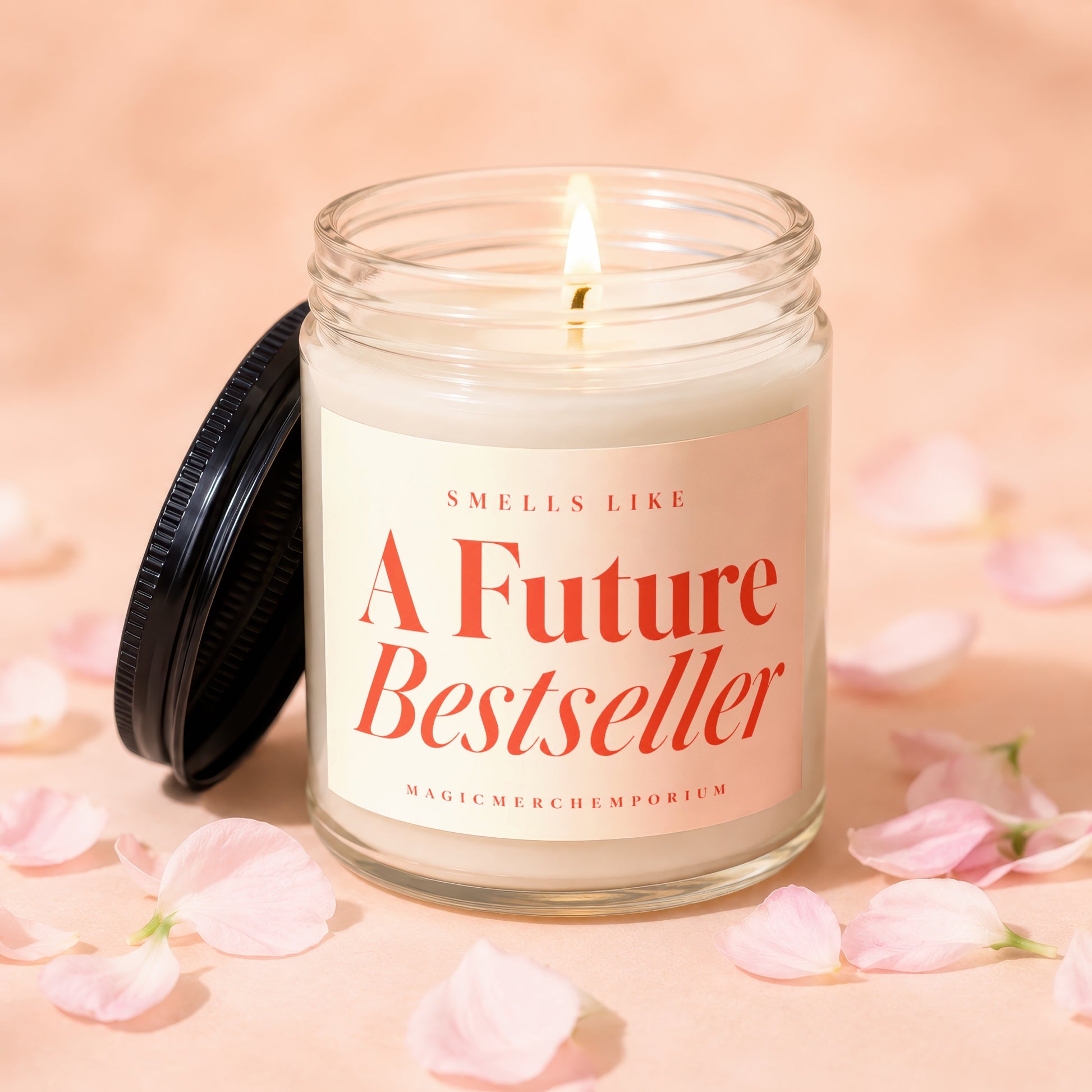 Lit candle in a glass jar with a pink label reading "Smells Like A Future Bestseller".