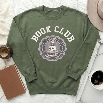 Green sweatshirt with "Book Club" text and skull graphic about reading.