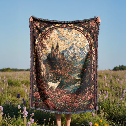 A person holds up a colorful, intricately designed tapestry featuring a castle, mountains, and a deer in a field with purple flowers.