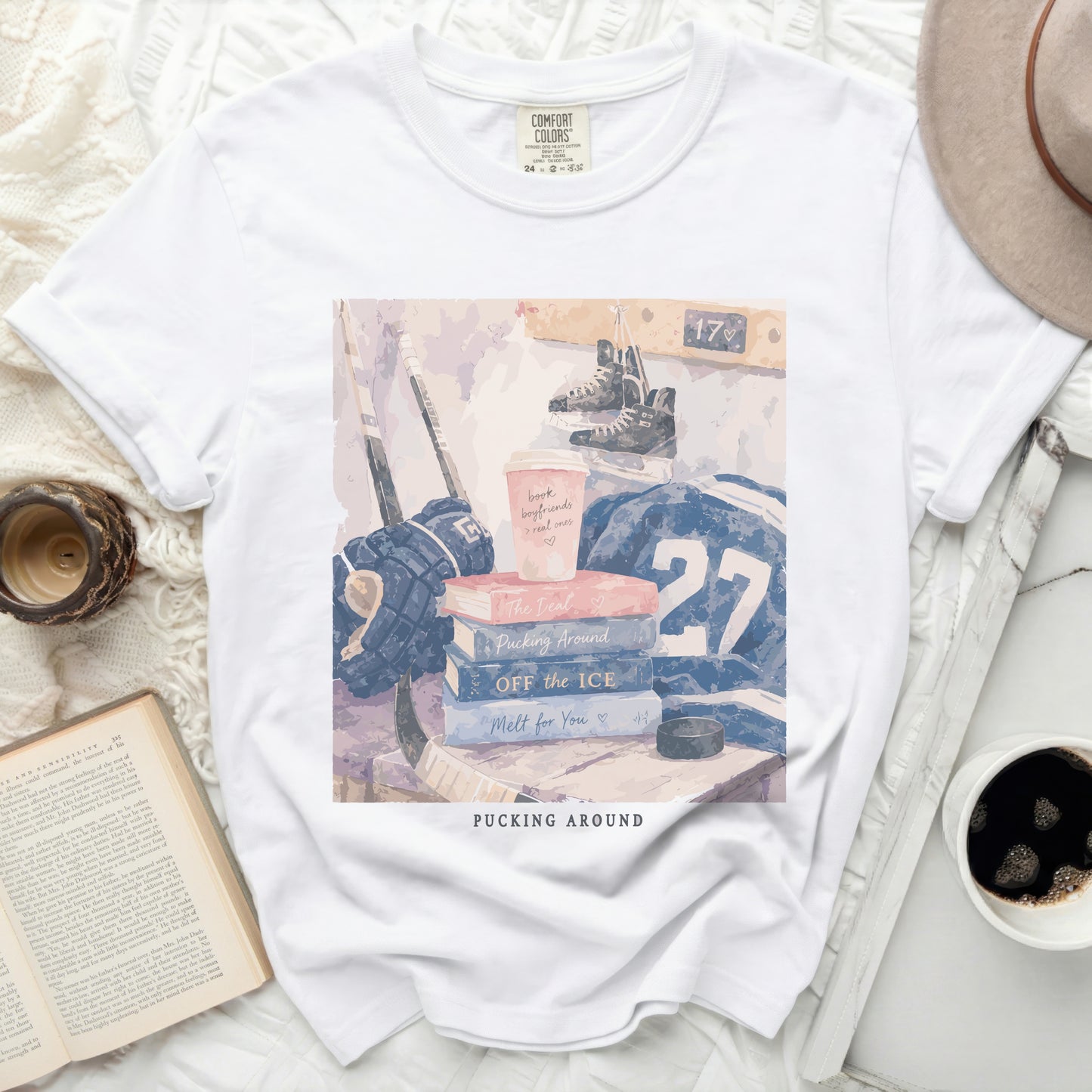 White t-shirt with "Pucking Around" text and hockey theme flat lay.