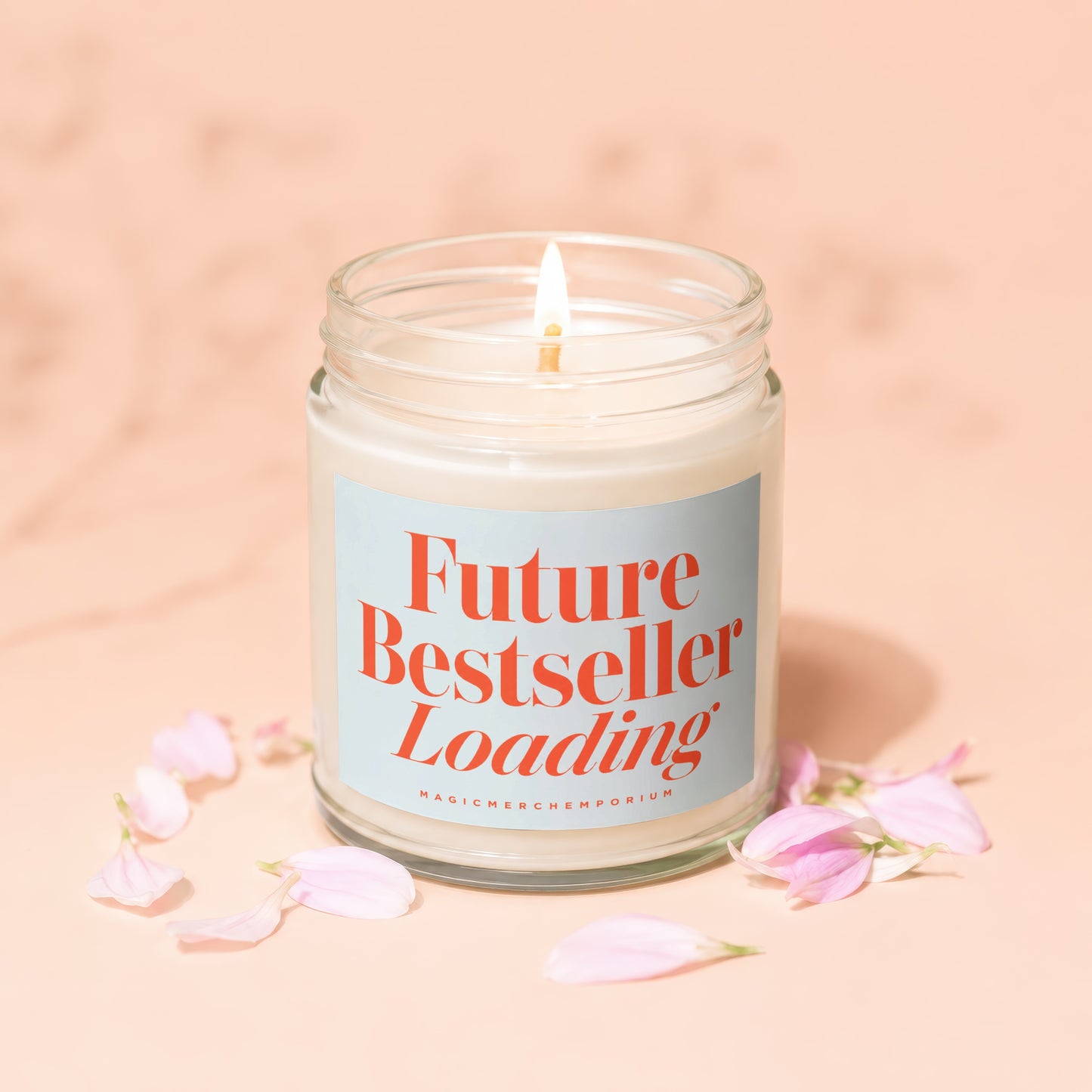 Lit candle in glass jar with "Future Bestseller Loading" text and petals.