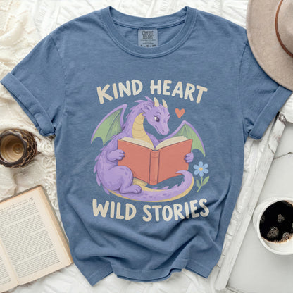 Purple dragon reading a book with text "KIND HEART WILD STORIES".