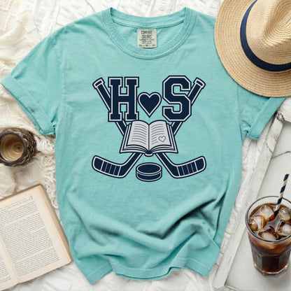 Teal t-shirt with book, hockey sticks, and "HS" design.