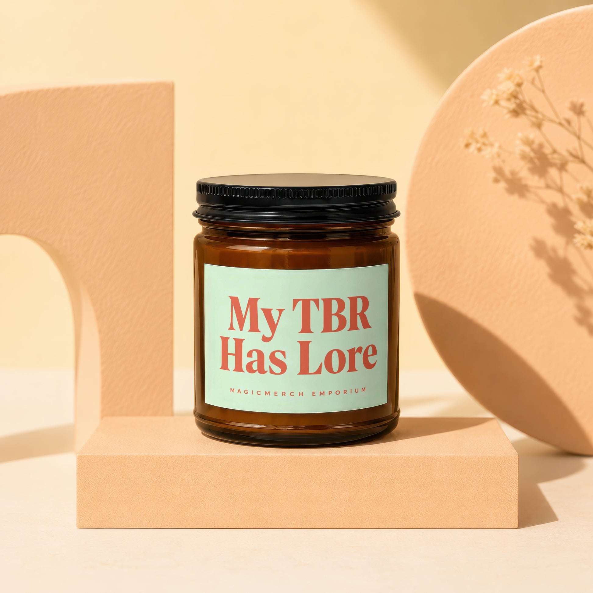 Amber glass candle with "My TBR Has Lore" text on a light green label.