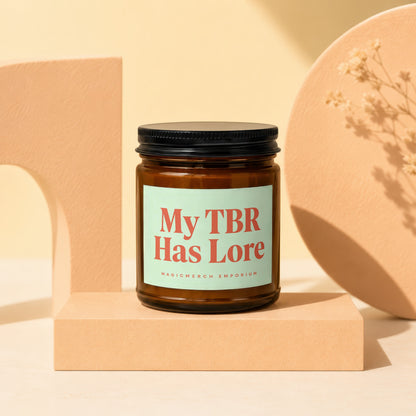 Amber glass candle with "My TBR Has Lore" text on a light green label.