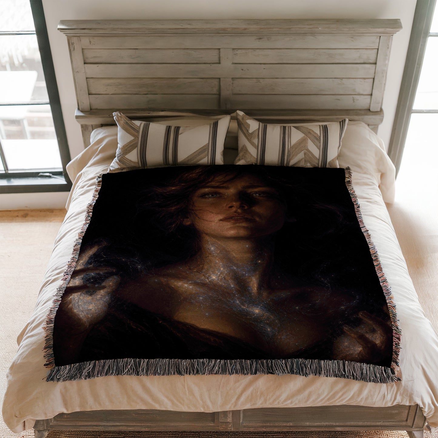 a bedroom with a bed covered in a blanket that has a large, artistic portrait of a woman on it. The woman appears to be gazing into the distance, creating a serene and contemplative atmosphere.