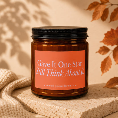 Amber candle in jar with orange label reading "Gave It One Star. Still Think About It."