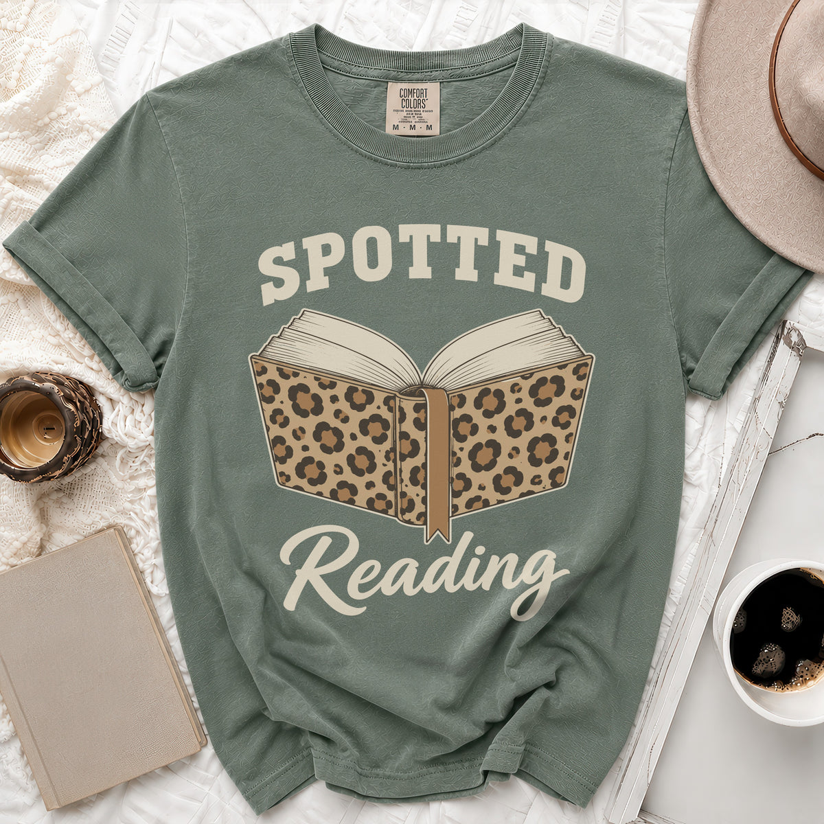 Green t-shirt with "Spotted Reading" text and a leopard print open book graphic.