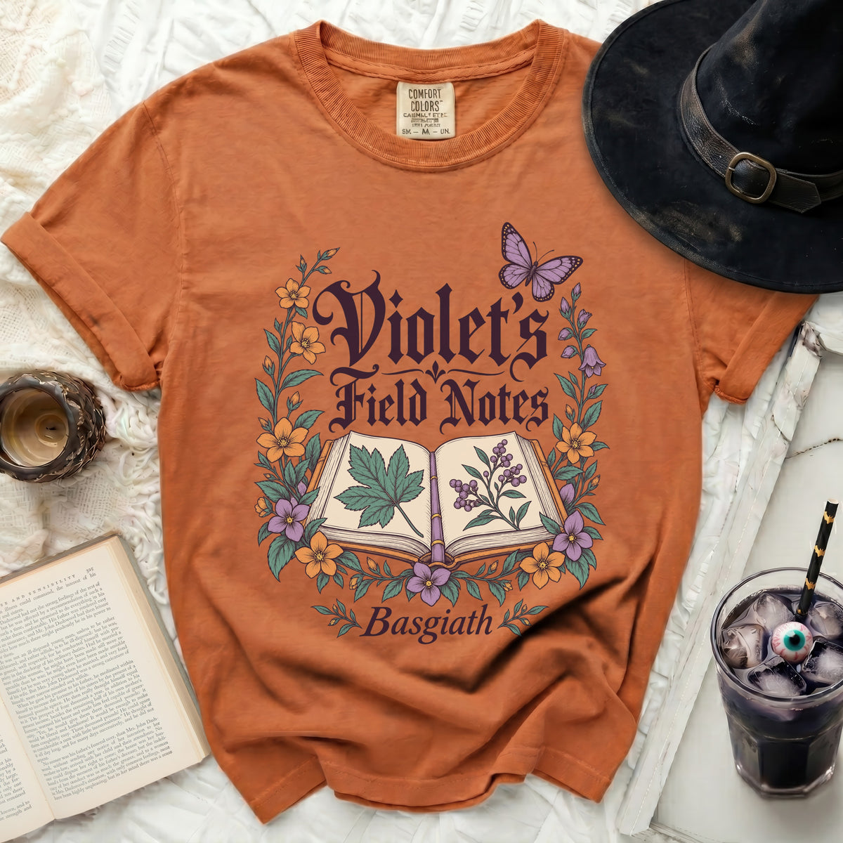 Orange t-shirt with "Violet's Field Notes Basgiath" text and floral design.