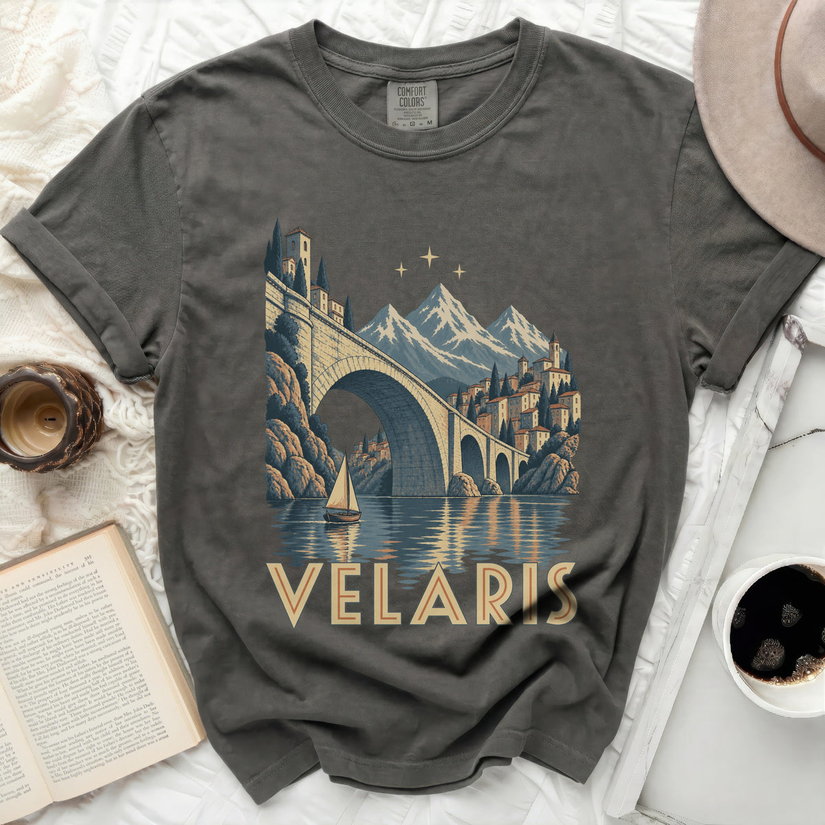 T-shirt with a vintage landscape print featuring Velaris, a bridge, mountains, and a sailboat.