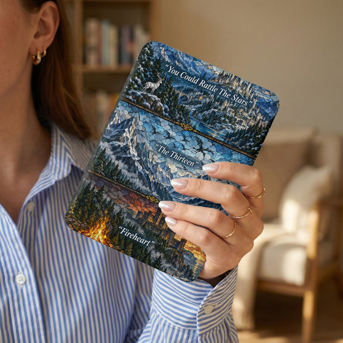 A person holding an e-reader featuring fantasy-themed stained glass artwork divided into three horizontal panels with quotes.