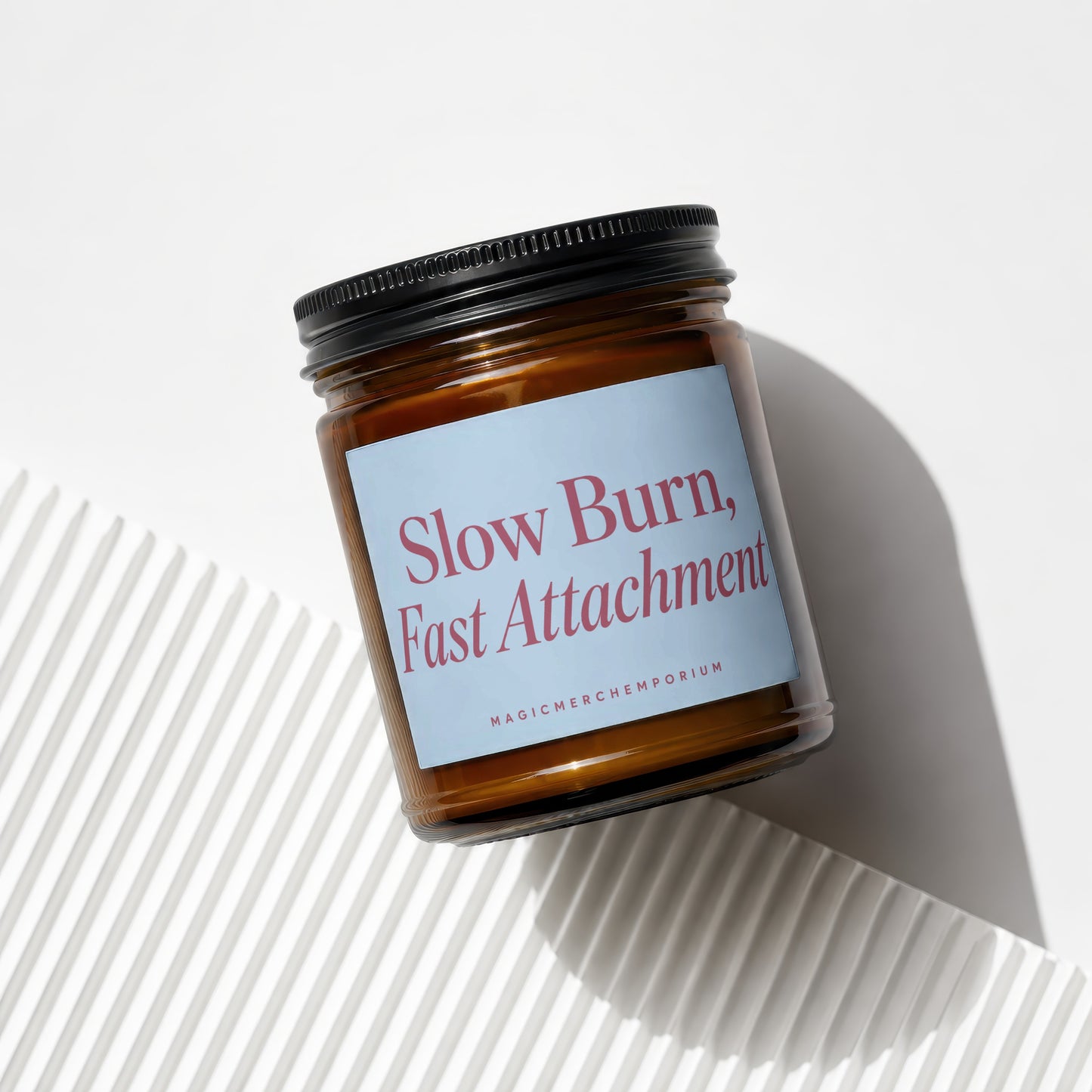 Glass jar candle with "Slow Burn, Fast Attachment" text and "MAGICMERCHEMPORIUM" logo.