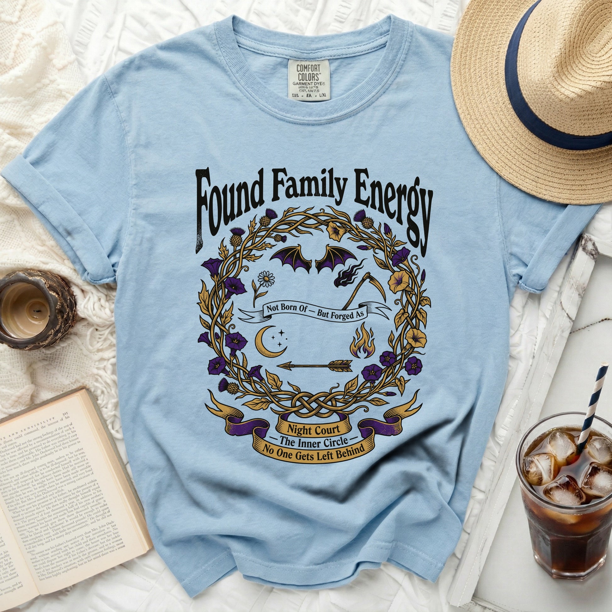 Light blue t-shirt with "Found Family Energy" and graphic design.