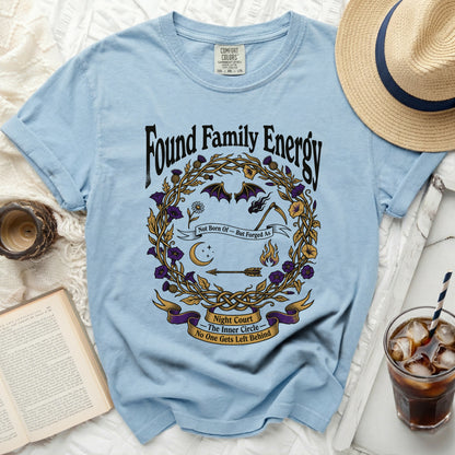 Light blue t-shirt with "Found Family Energy" and graphic design.