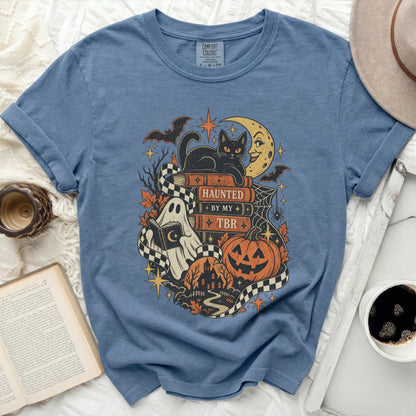 Halloween graphic t-shirt with black cat, ghost, pumpkin, and text "Haunted By My TBR".