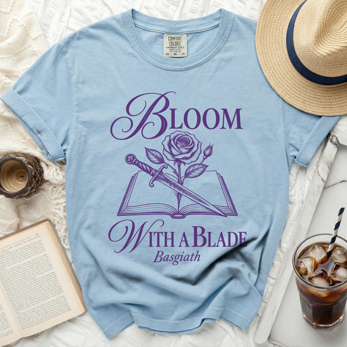 Light blue t-shirt with purple text "Bloom With a Blade Basgiath" and rose/dagger design.