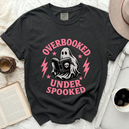 Black t-shirt with a ghost reading a book and text "OVERBOOKED UNDER SPOOKED".