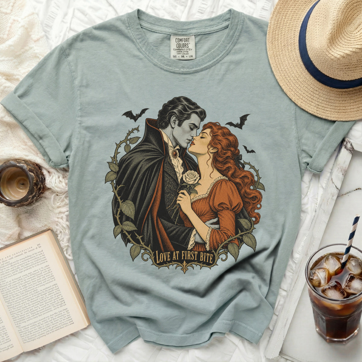 Vampire couple kissing surrounded by thorns and bats, with "Love at First Bite" text.
