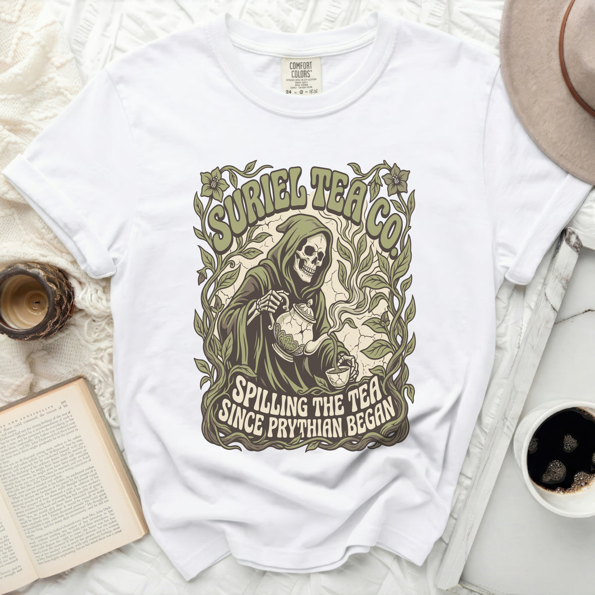 White t-shirt with a grim reaper pouring tea, "Suriel Tea Co." and "Spilling the tea since Pythian began."