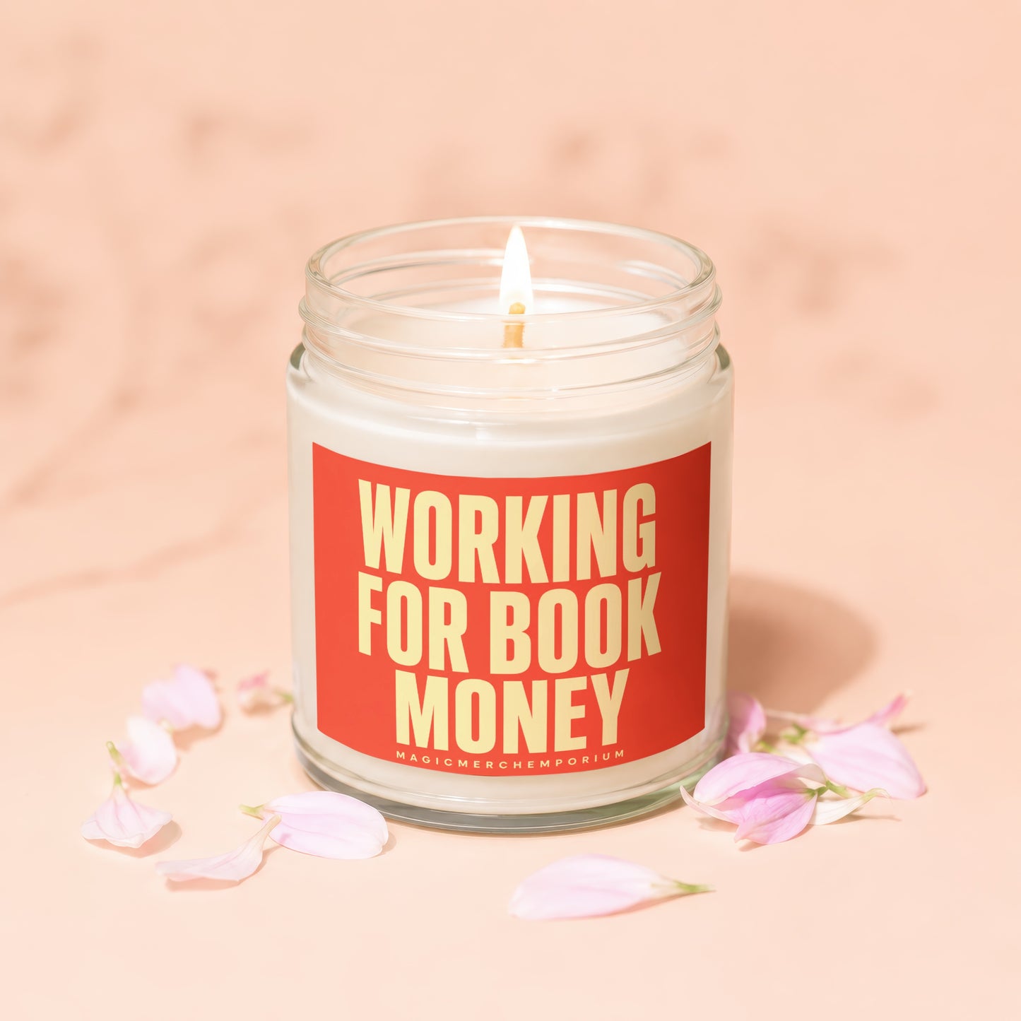 Jar candle with lit wick, reads "Working For Book Money" in yellow text.