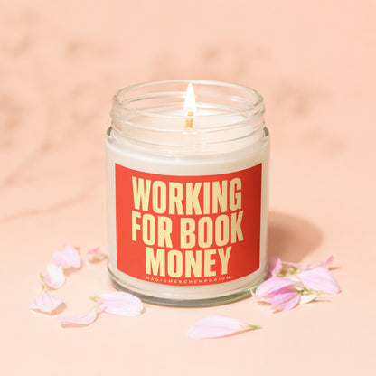 Jar candle with lit wick, reads "Working For Book Money" in yellow text.