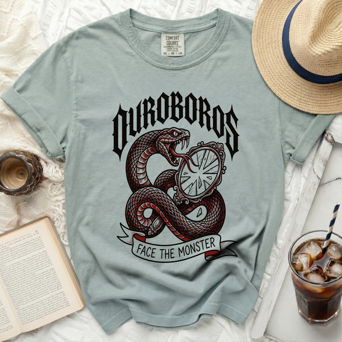 Ouroboros snake coiled around a mirror, text "Face the Monster" on a banner.
