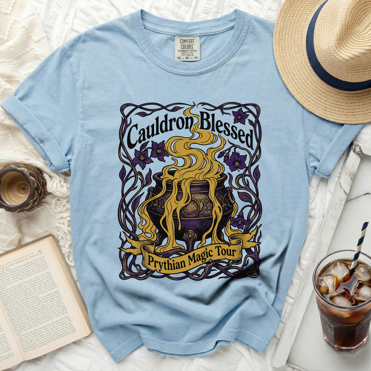 Light blue t-shirt with a graphic that reads "Cauldron Blessed Prythian Magic Tour."