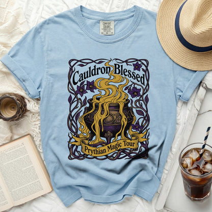 Light blue t-shirt with a graphic that reads "Cauldron Blessed Prythian Magic Tour."