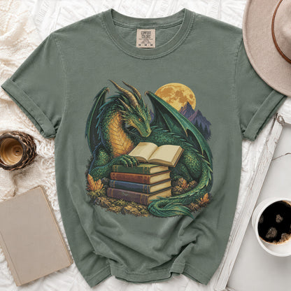 Green dragon reading a book on a stack of books under a full moon.