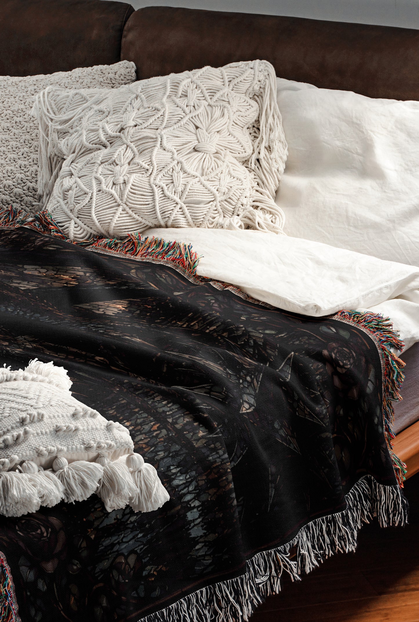 a cozy and inviting bedroom scene, featuring a bed with a black and white patterned blanket, a white pillow, and a white throw blanket. The bed is set against a brown leather headboard, creating a warm and comfortable atmosphere.
