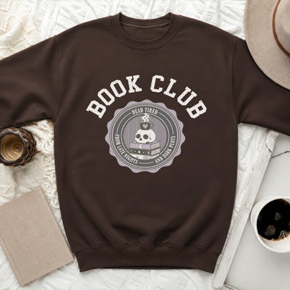 Brown sweatshirt with "Book Club" text and skull with coffee, books, and moon graphic.