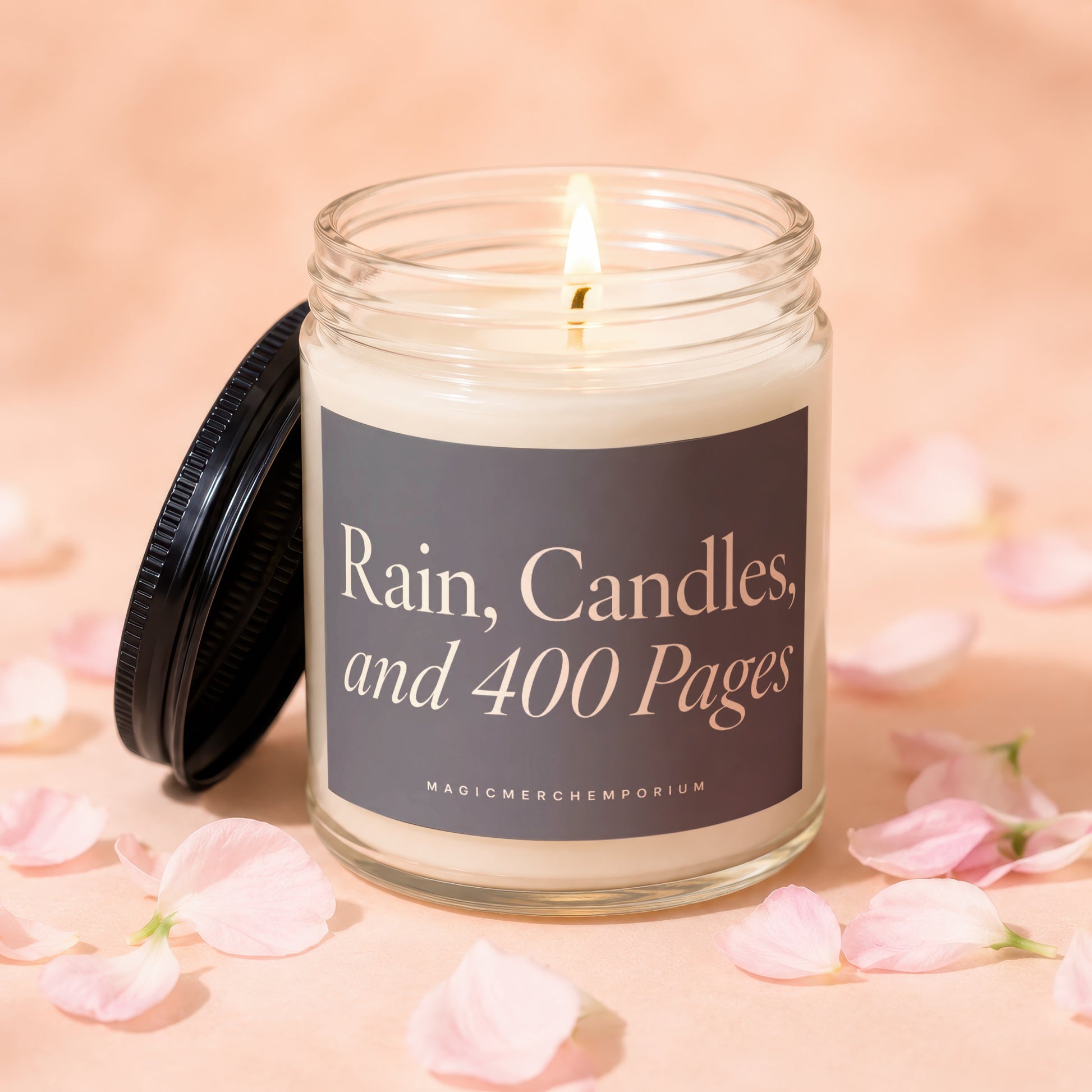 Jar candle with lit wick, lid ajar, reads "Rain, Candles, and 400 Pages".