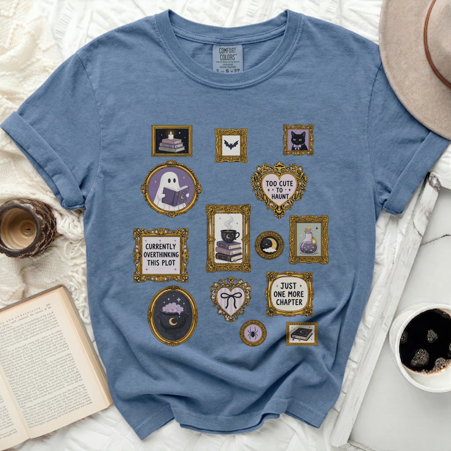 Blue t-shirt with framed Halloween-themed graphics including a ghost with a book.