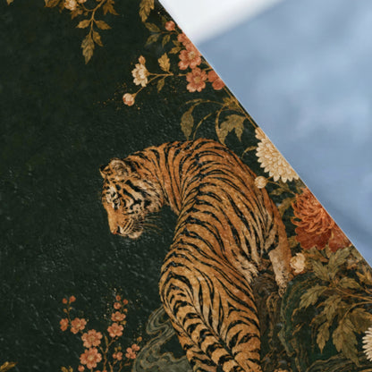 Tiger amongst dark green floral patterns and foliage, right side blurred.