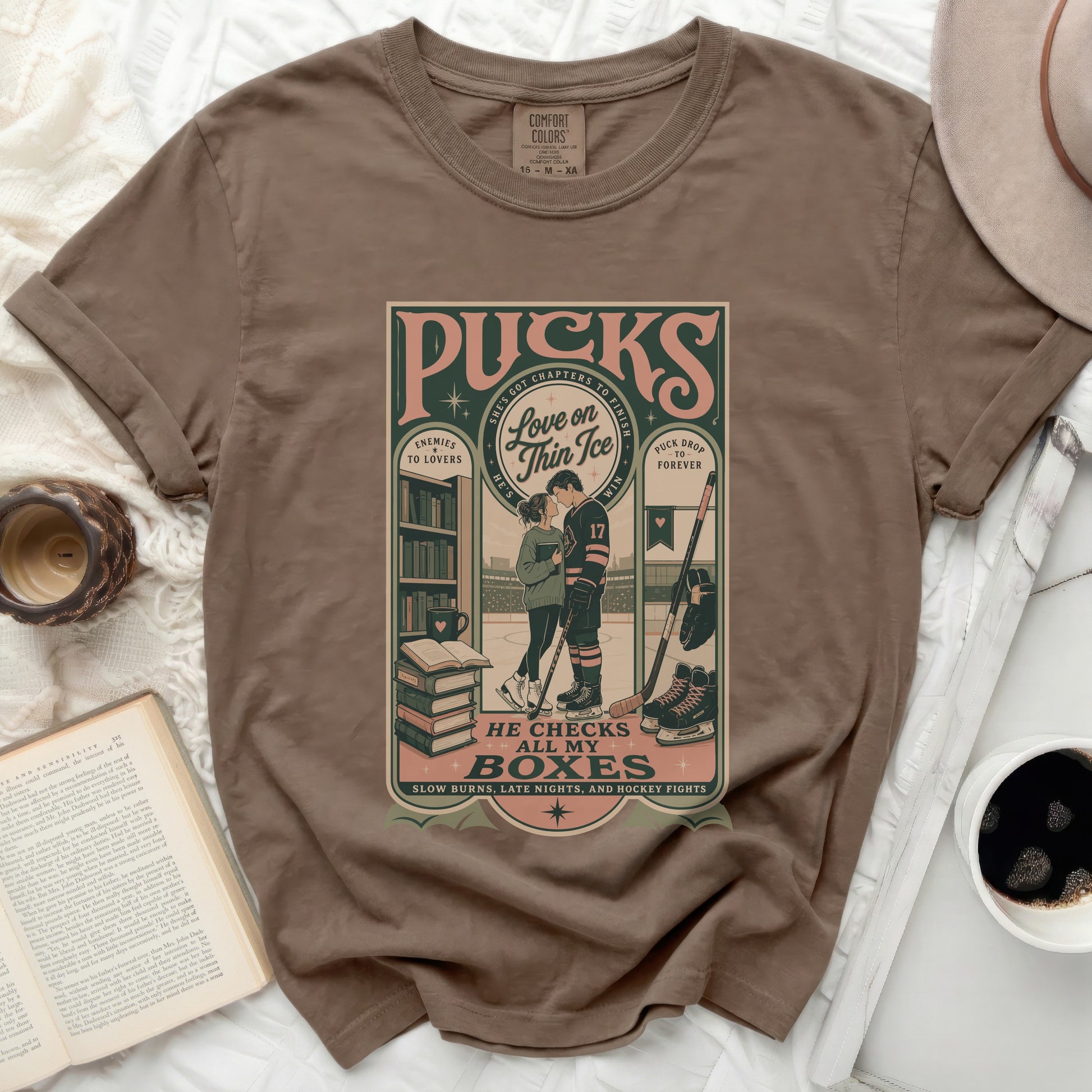 Brown t-shirt with "Pucks Enemies to Lovers" hockey graphic and text.
