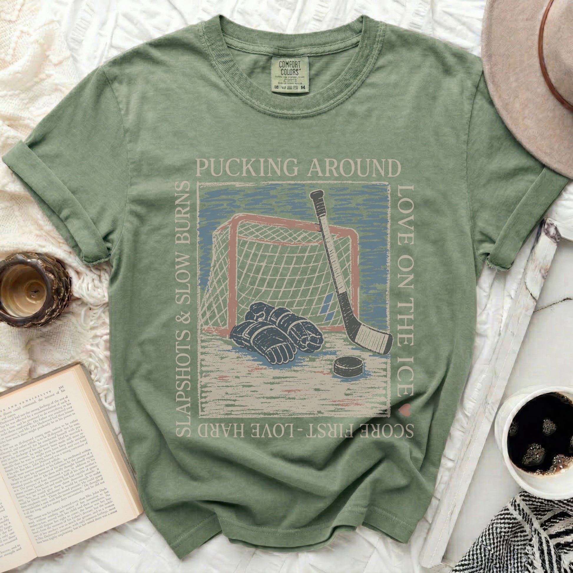 T-shirt with hockey graphic and text: pucking around, love on the ice, slapshot slow burns.