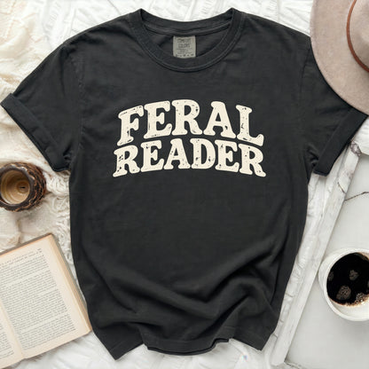 Dark gray t-shirt with "FERAL READER" text in distressed cream font.