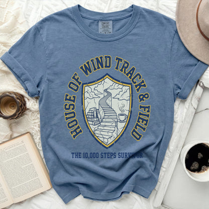 Blue Comfort Colors t-shirt with shield logo and text "HOUSE OF WIND TRACK & FIELD THE 10,000 STEPS SURVIVOR."